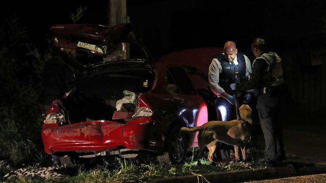 Tasmanian police inspect a car out the front of a Magra property on Back River Road. Picture: Zak Simmonds