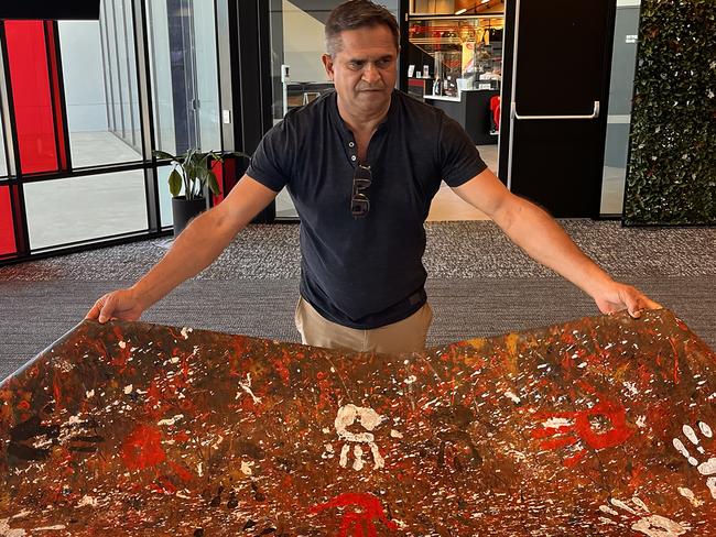 Nicky Winmar with artwork featuring handprints of the 1993 St Kilda side Photo: Lis Johnston