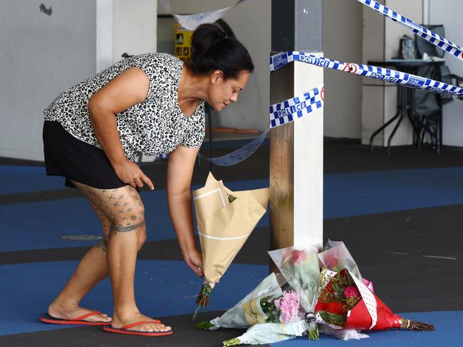 A woman places flowers at the scene on Sunday. Picture Lachie Millard