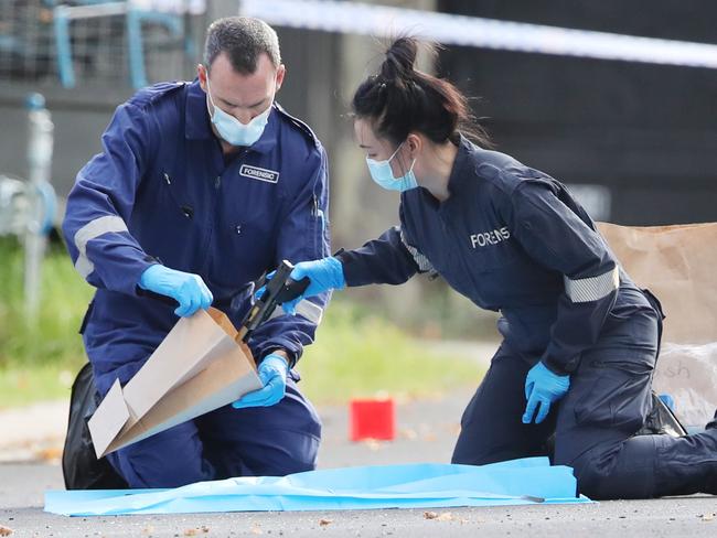 Police at the scene of a fatal shooting in Caroline Springs. Pic of police picking up the gun. Friday, January 10. 2024. Picture: David Crosling