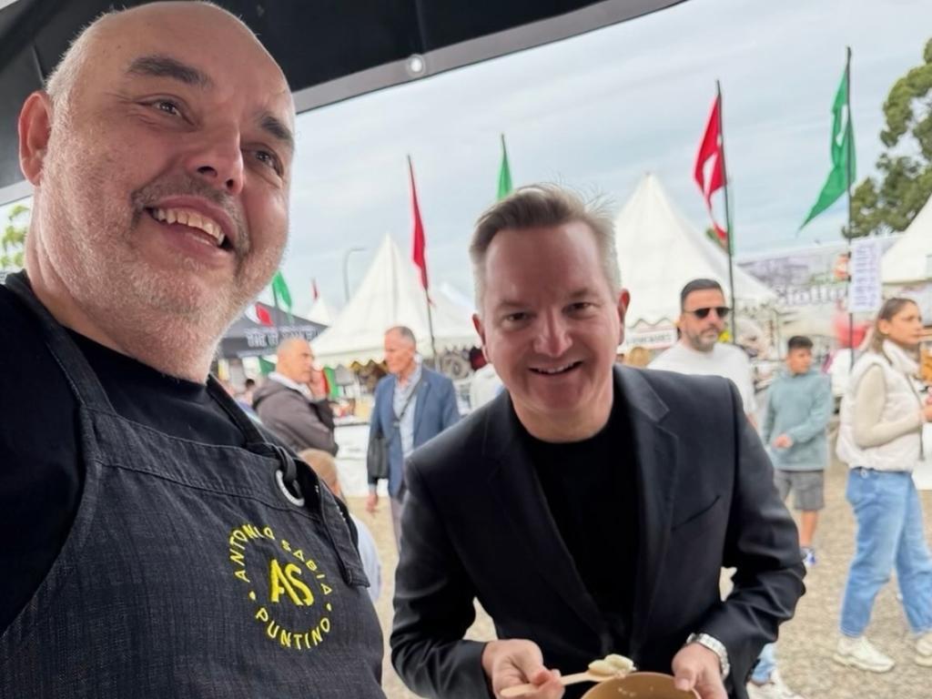 Chris Bowen purchasing the bowl of pasta from a festival stall.