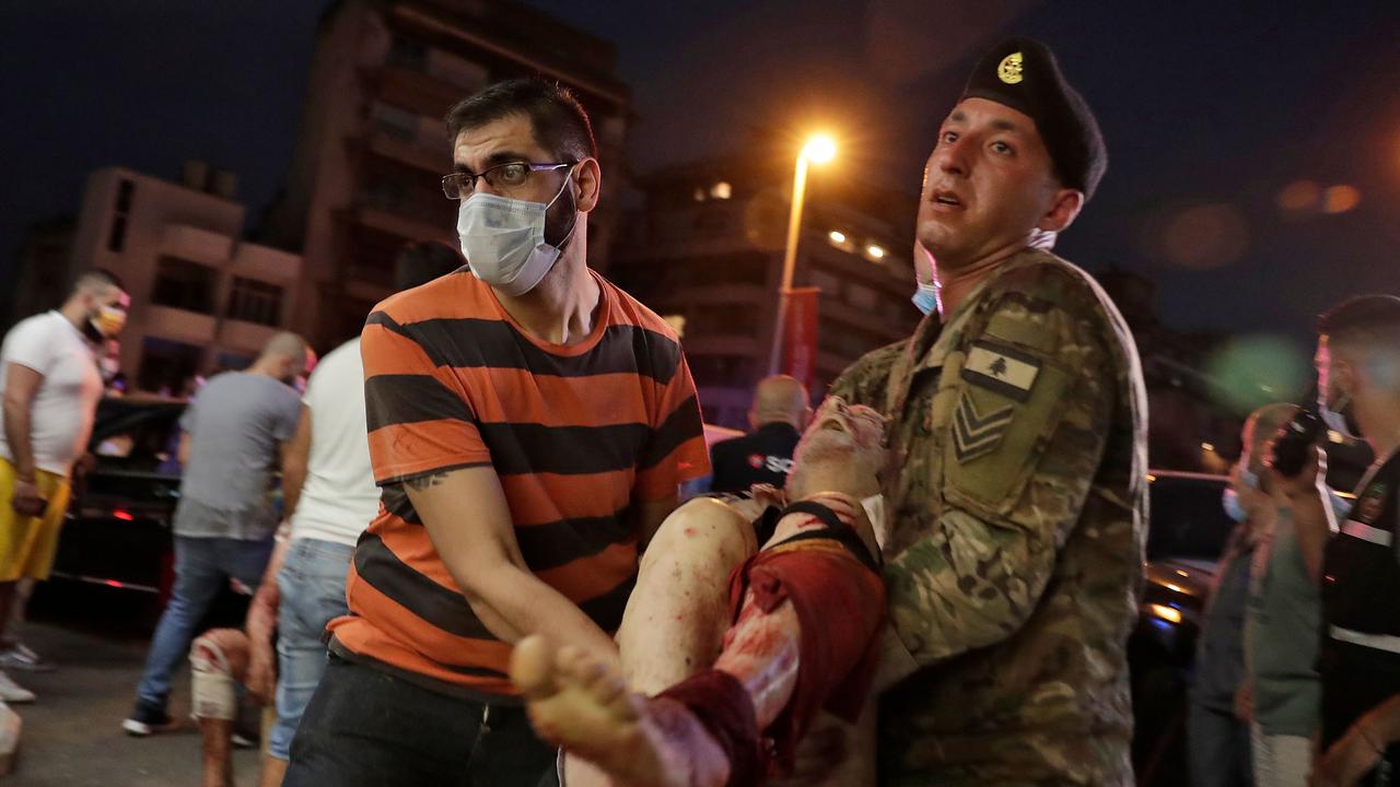 A Lebanese army soldier and a man carry away an injured man at a hospital. Picture: AFP