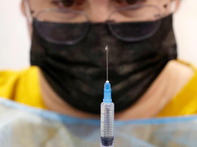 A healthcare worker prepares a dose of the Pfizer-BioNtech COVID-19 vaccine in Tel Aviv.