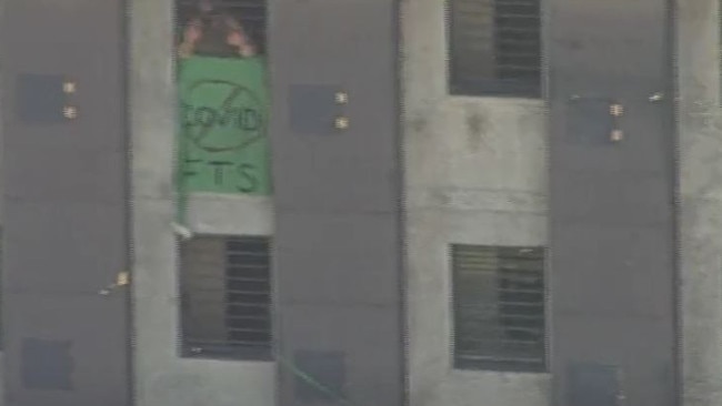 Prisoners display a banner that reads COVID FTS (F**k That S**t). Picture: 7 News