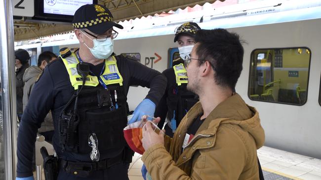 Police and Public Safety Officers enforce mask-wearing at Flinders Street Station in Melbourne following the new Covid outbreak. Picture: Andrew Henshaw