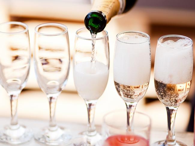 Waiter serving a glass of sparkling white wine