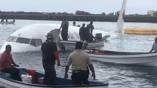 Locals approach the crashed Air Niugini aircraft. Picture: AFP