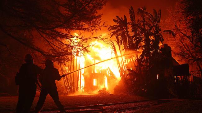 A Los Angeles County firefighters spray water on a burning home as the Eaton Fire in Altadena, California. Picture: AFP