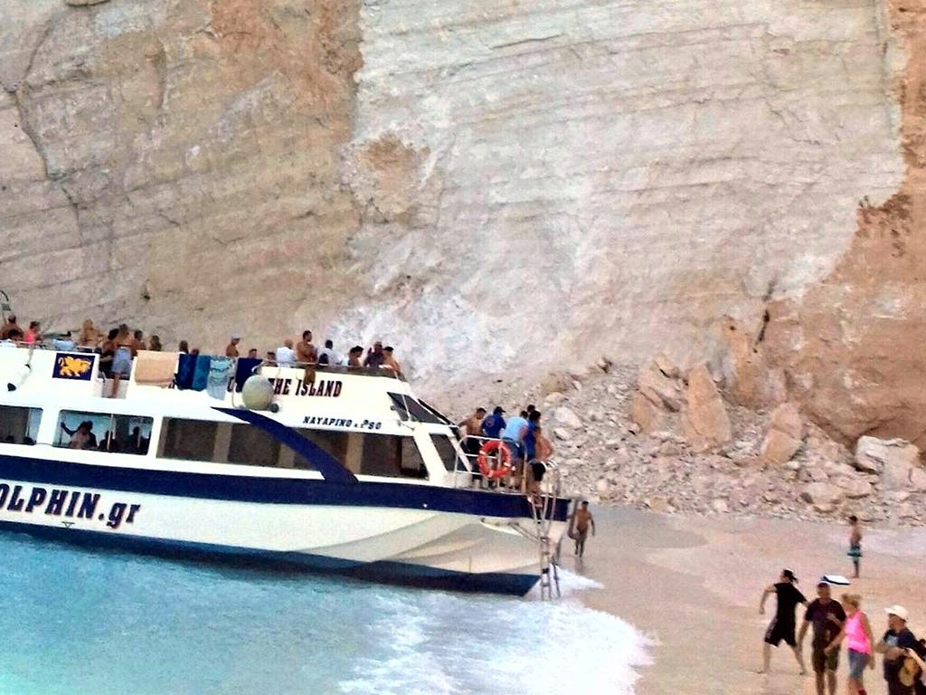 People get on a boat to leave the beach after the landslide. Picture: imerazante.gr via AP