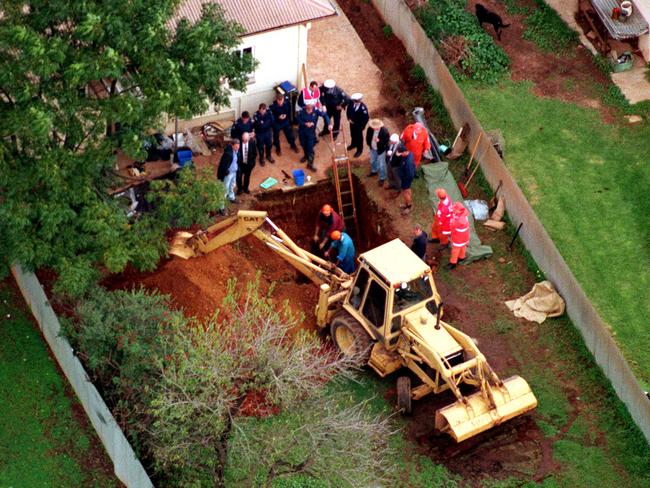 Police digging in the backyard of the Salisbury North home where two bags of human remains were found.