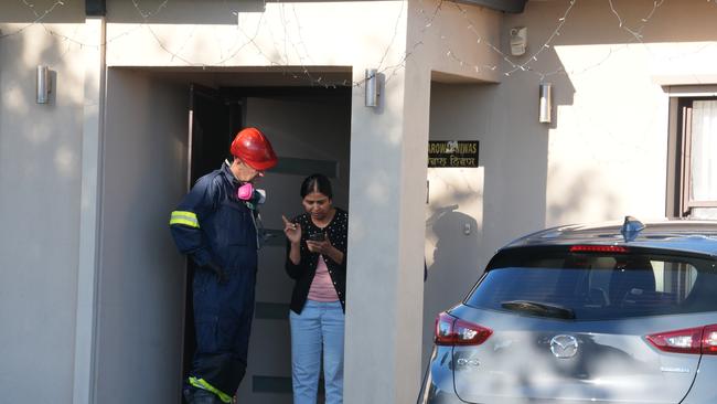 A fire investigator talks to a neighbour. Picture: Dean Martin