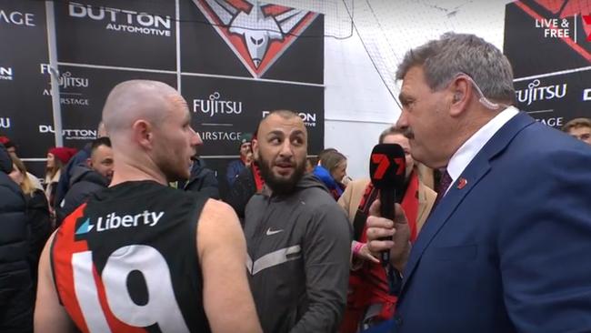 Kamil Yucel (centre) in the Essendon rooms with Nick Hind. Photo: Channel 7.