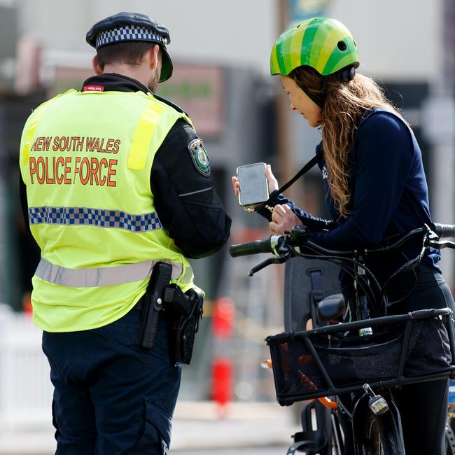 A police officer takes a rider’s details at Manly Beach on Wednesday. Picture: NCA NewsWire / Nikki Short