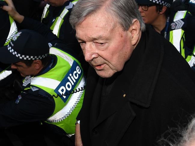 Cardinal George Pell arrives, surrounded by Victorian Police officers at the Melbourne Magistrates Court in Melbourne, Australia, Wednesday, July 26, 2017. Australia's most senior Catholic, Cardinal George Pell will make his first court appearance as he fights historical sexual offence charges. (AAP Image/Tracey Nearmy) NO ARCHIVING