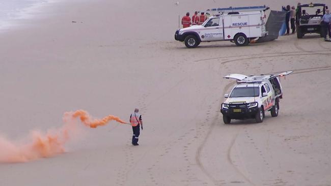 Emergency services let off flares as paramedics work on the shark attack victim. Picture: Frank Redward