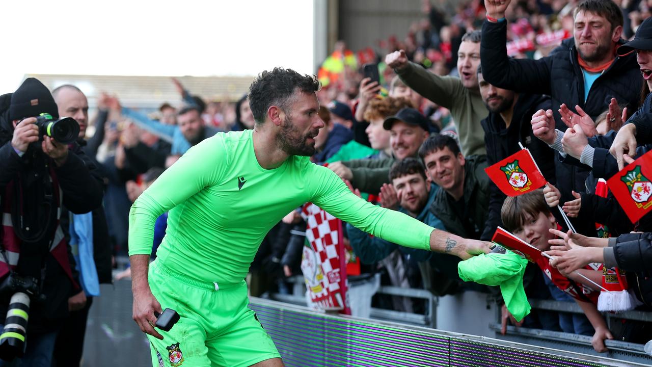 Ben Foster of Wrexham gives their shirt to a fan after their side's victory.