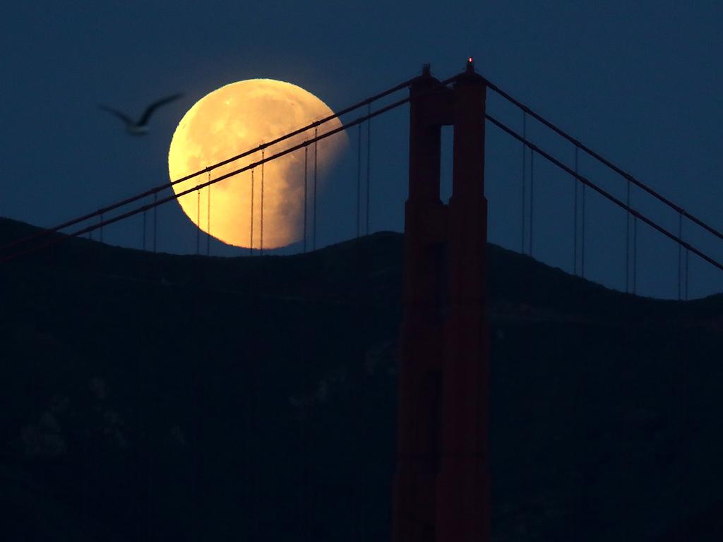 A partially eclipsed super blue blood moon sets behind the Golden Gate Bridge on January 31, 2018 in San Francisco, California. The ‘super blue blood moon’ is a rare ‘lunar trifecta’ event in which the Moon is at its closest to the Earth, appearing about 14 percent brighter than usual, and is simultaneously a ‘blue moon’, the second full moon in the same month, as well as a total lunar eclipse or ‘blood moon’. This is the first such lunar event seen in North America since 1866. Picture: Getty