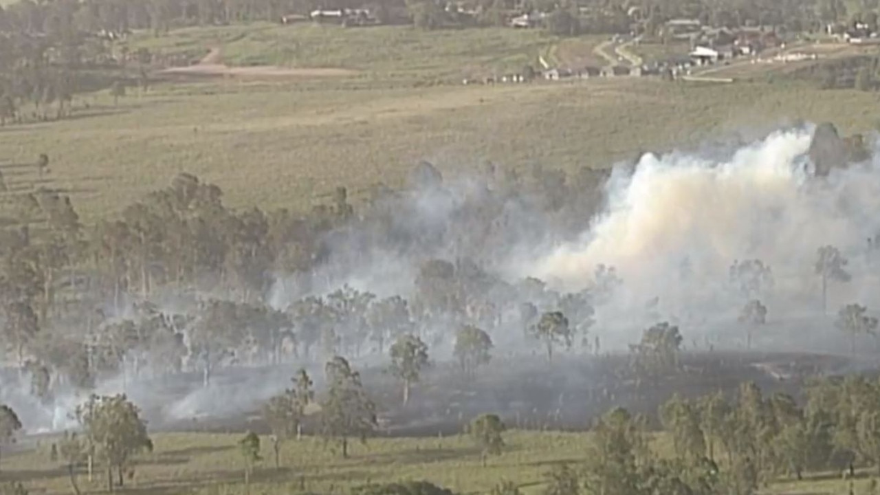 Screenshots from live footage showing a major bushfire burning in Beaudesert.