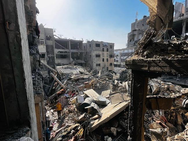 Palestinians search throught the rubble of a building after an Israeli strike in Beit Lahia, in the northern Gaza Strip, on October 29, 2024, amid the ongoing war in the Palestinian territory between Israel and Hamas. Gaza's civil defence agency said on October 29, that an overnight Israeli air strike killed more than 55 people in a residential building in the northern district of Beit Lahia. (Photo by AFP)