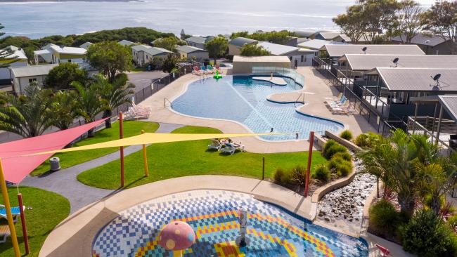 4/12NRMA Merimbula Beach Holiday ResortNew South Wales An award-winning holiday resort with a variety of camping and accommodation options, this escape on the NSW Far South Coast has excellent facilities and million-dollar views of the Sapphire Coast and Merimbula Beach. Families will go nuts for the waterpark, playground, swimming pool and bouncing pillow, as well as the tennis court and woodfired pizza oven, but the views and easy access to the beach are reason enough to become a frequent flyer here. Picture: Supplied