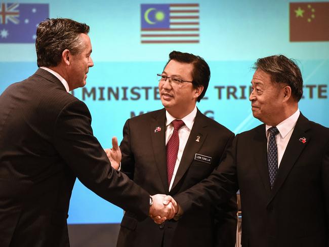 Malaysia's Transport Minister Liow Tiong Lai, Australia's Minister for Infrastructure and Transport Darren Chester and Chinese Minister of Transport Yang Chuantang shake hands after a joint press conference of the Ministerial Tripartite Meeting on the search for missing Malaysia Airlines flight MH370. Picture: AFP