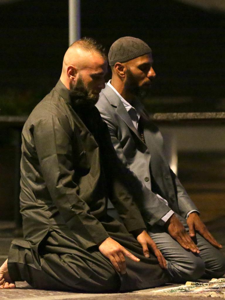 Early morning vigil ... Sam Tiger, right, and Abdulrahman El-Lawn pray for peace and for those affected by the siege, especially the hostages and their families. Picture: Glenn Nicholls (AP)