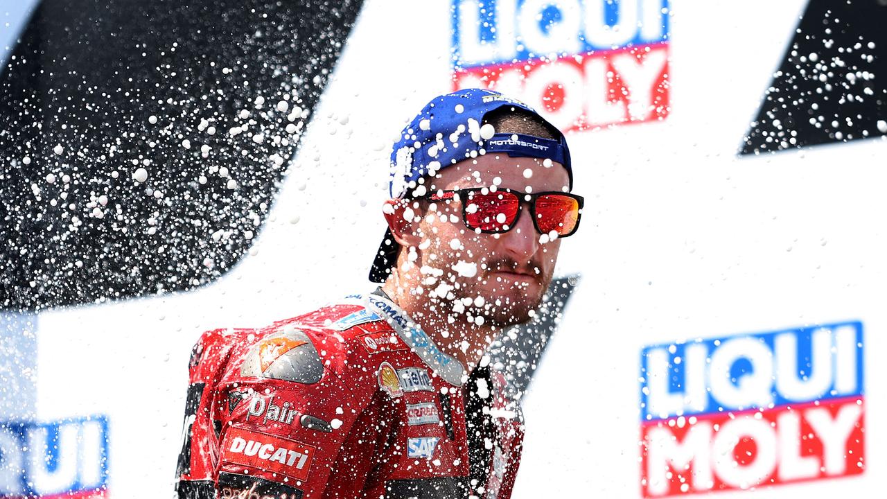 Third placed Ducati Lenovo's Australian rider Jack Miller celebrates on the podium after the German MotoGP Grand Prix at the Sachsenring racing circuit in Hohenstein-Ernstthal near Chemnitz, eastern Germany, on June 19, 2022. (Photo by Ronny Hartmann / AFP)