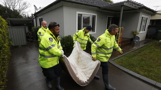 For some, the clean-up has begun. RFS firefighters pictured helping Camden residents clean up their homes on Monday after they were flooded when the Nepean River bursts it banks. Picture: Jonathan Ng