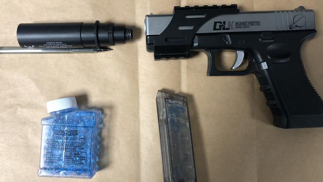 A Glock-18 replica 'Gel Blaster' pistol, along with a silencer and 'ammunition', seized from a man by Northern Beaches Police after receiving a triple zero call from a member of the public reporting seeing a man with a gun at a popular beach lookout. Picture: NSW Police