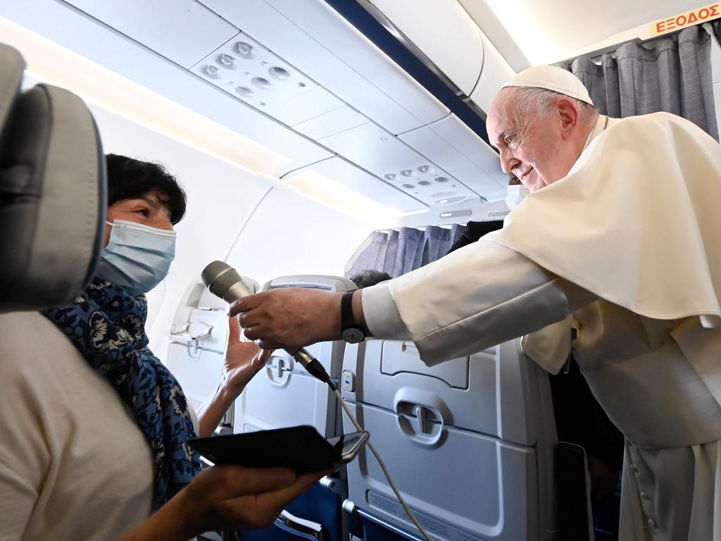 Pope Francis holding the microphone for a journalist to speak as he gives a news conference aboard the papal plane on his flight back to Rome after visiting Cyprus and Greece on December 6, 2021. Picture: Handout / VATICAN MEDIA / AFP