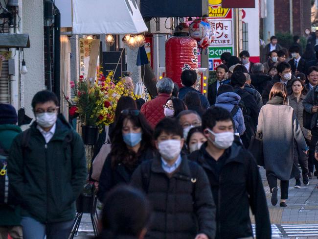 People make their way along a sidewalk in Tokyo on February 17, 2025. Japan's economic growth slowed sharply in 2024, cabinet office data showed on February 17, although the rate for the fourth quarter beat market expectations thanks to strong exports. (Photo by Kazuhiro NOGI / AFP)