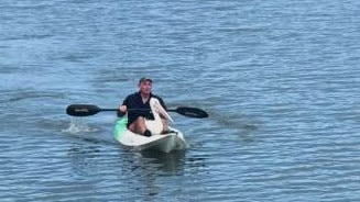 Rowley Goonan from Wild Bird Rescue Gold Coast saves a pelican by kayaking out to grab her. Picture: supplied