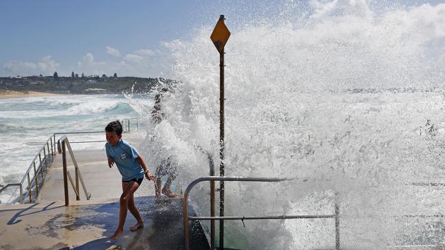 Locals at Curl Curl on Sydneys northern beaches run for cover as huge waves smash the South Curl Curl Ocean Pool. Picture: Richard Dobson