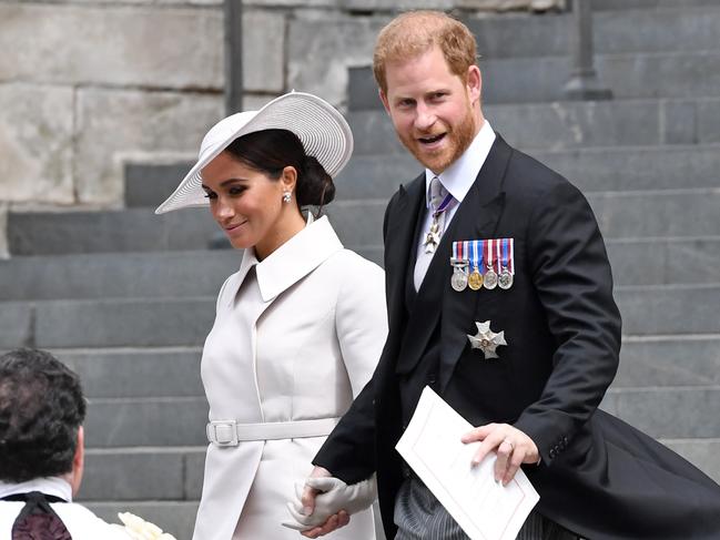 A custom Dior moment from Meghan Markle, left, with Prince Harry. Picture: Getty Images