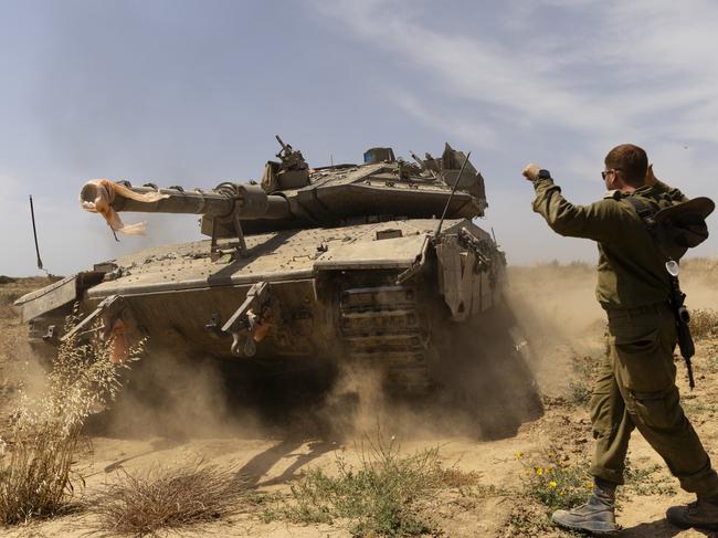 An Israeli soldier directs a tank near the border with the southern part of the Gaza Strip. Picture: Getty Images