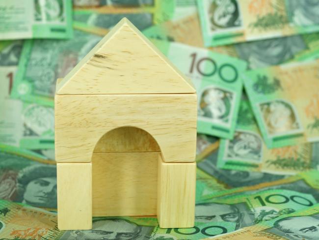 Wooden block house on a background of $100 notes, Australian money housing generic