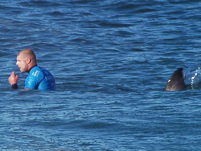 A shark sneaks up on Mick Fanning at Jeffreys Bay in 2018.