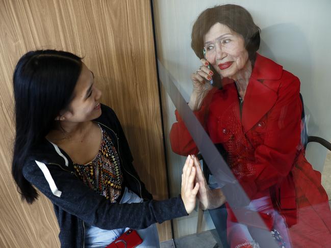 Kya Wong visiting her grandmother Diday Hernandez, 90, through the glass front doors of Ms Hernandez’s nursing home. Picture: Sam Ruttyn