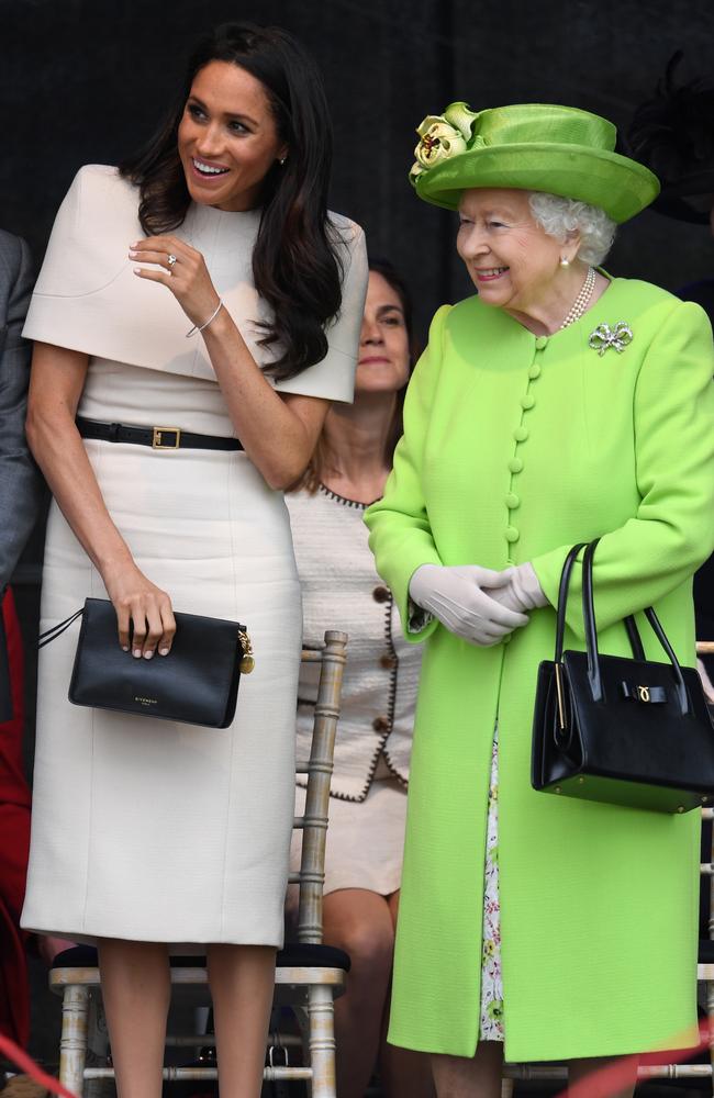 Queen Elizabeth II stands and laughs with Meghan, Duchess of Sussex. Picture: Getty