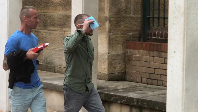 Smith covered his face as he left court with a supporter.