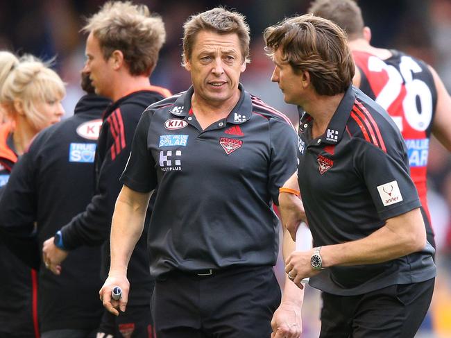 MELBOURNE, AUSTRALIA - AUGUST 11:  Bombers assistant coach Mark Thompson (L) speaks to coach James Hird at three quarter time during the round 20 AFL match between the Essendon Bombers and the West Coast Eagles at Etihad Stadium on August 11, 2013 in Melbourne, Australia.  (Photo by Michael Dodge/Getty Images)