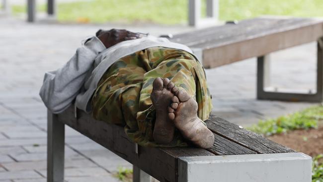 A homeless man sleeps on a bench seat in the Shields Street Mall. Picture: Brendan Radke