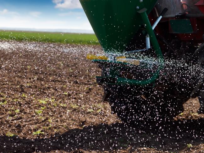 Tractor in springtime fertilizing action. Fertiliser spreader istock