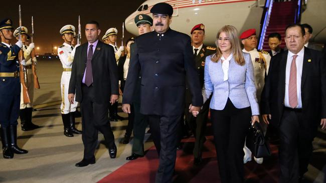 This handout picture released by the Venezuelan Presidency shows Venezuelan President Nicolas Maduro (C) and his wife Cilia Flores (2-R), disembarking from their plane in Beijing, on September 13, 2018. - Maduro arrived in China to strike deals with his crisis-hit country's biggest creditor. Before departing Caracas, Maduro said the trip was "very necessary, very opportune and full of great expectations." (Photo by Francisco BATISTA / Venezuelan Presidency / AFP) / RESTRICTED TO EDITORIAL USE - MANDATORY CREDIT "AFP PHOTO - Venezuelan Presidency / Francisco BATISTA" - NO MARKETING NO ADVERTISING CAMPAIGNS - DISTRIBUTED AS A SERVICE TO CLIENTS