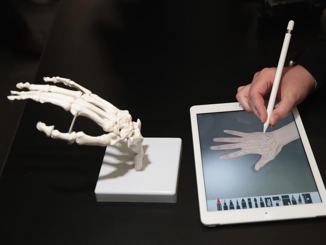 A guest draws the bones of the hand on Apple's new 9.7-inch iPad during an event held to introduce the device at Lane Tech College Prep High School in Chicago. Picture: Scott Olson/Getty Images/AFP