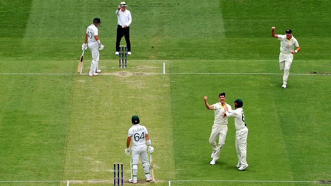 Pat Cummins of Australia celebrates with team mates after taking the wicket of Dean Elgar. (Photo by Bradley Kanaris/Getty Images)