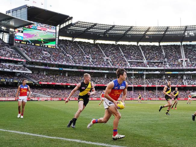 The large crowd is seen as Jarryd Lyons of the Lions runs with the ball during the Round 25 AFL match between the Richmond Tigers and the Brisbane Lions at the MCG in Melbourne, Sunday, August 25, 2019. The AFL today announced a new attendance record for a season. (AAP Image/Michael Dodge) NO ARCHIVING, EDITORIAL USE ONLY