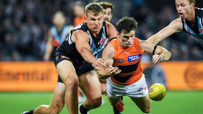 Brent Daniels and Ollie Wines, both wearing black armbands, go head-to-head at Adelaide Oval. Picture: Mark Brake/Getty Images