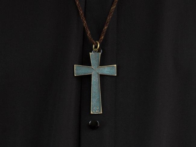 Priest, crucifix and hands