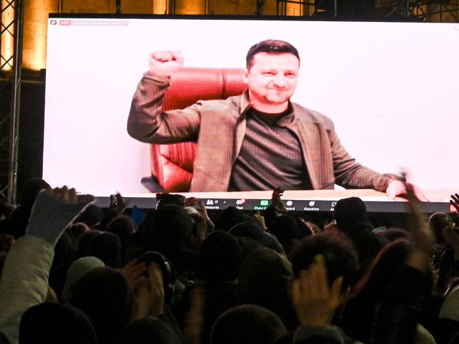 TOPSHOT – Demonstrators watch an address of Ukrainian President Volodymyr Zelensky on the big screen during a rally in support of Ukraine in Tbilisi on March 4, 2022. (Photo by Vano SHLAMOV / AFP)